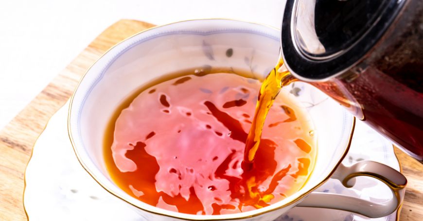 black tea being poured into a cup